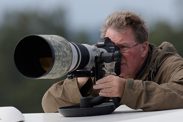 Jan fotograferar med ett teleobjektiv.