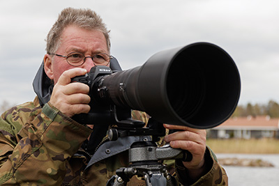 Jan fotograferar med ett Nikon teleobjektiv.